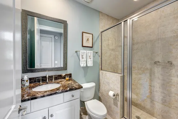 a bathroom with a granite countertop sink toilet and shower