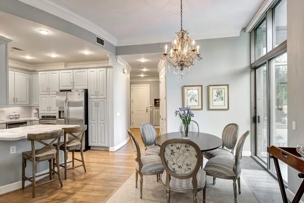 a dining room with furniture a chandelier and wooden floor