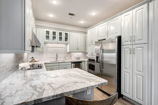 a kitchen with stainless steel appliances granite countertop a refrigerator sink and stove
