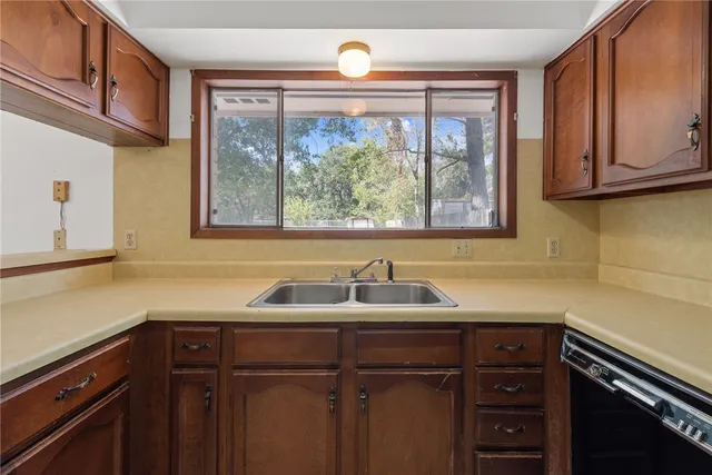 a kitchen with a sink a window and cabinets