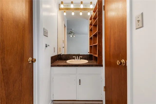 a bathroom with a granite countertop sink and a mirror