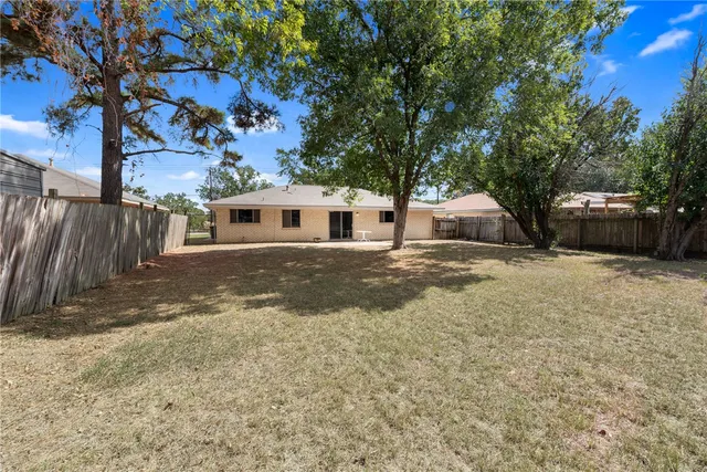 a view of a house with a tree in the yard