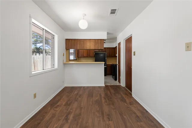 a view of a kitchen with wooden floor and a window