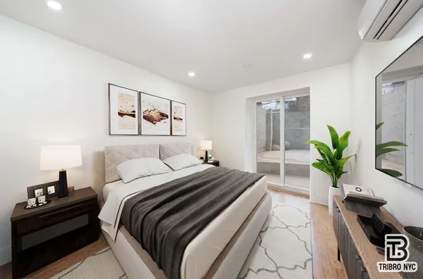 a bedroom with a large bed and a potted plant