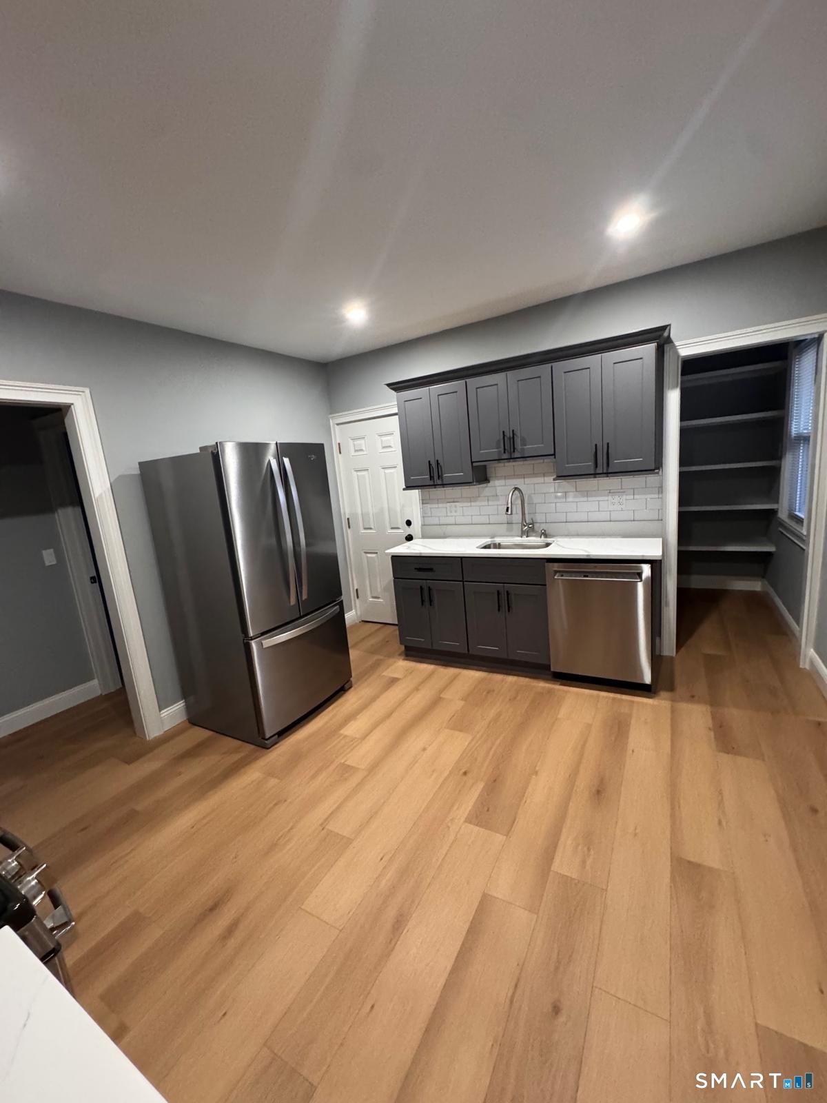 a view of kitchen with sink and refrigerator