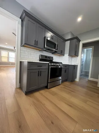 a kitchen with stainless steel appliances granite countertop a stove a sink and a microwave