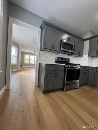 a kitchen with stainless steel appliances granite countertop a stove a sink and a microwave