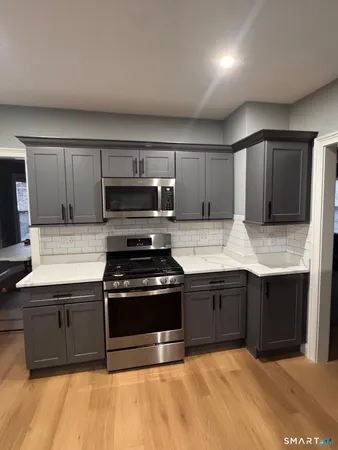 a kitchen with stainless steel appliances granite countertop a stove a microwave and a refrigerator