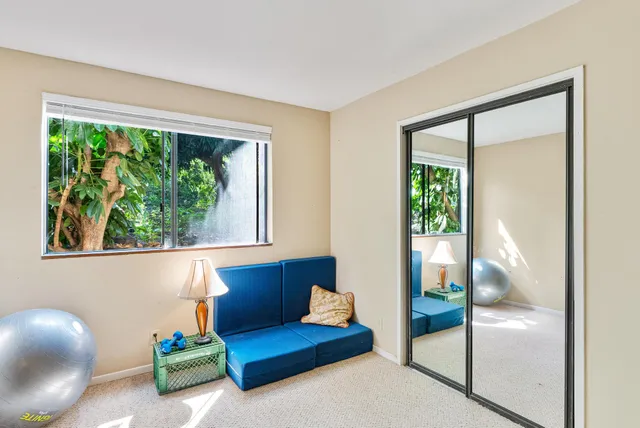 a living room with furniture a flat screen tv and a floor to ceiling window