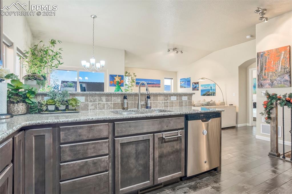 835 Citrine View Colorado Springs, CO 80921 - Photo 14 of 50 a kitchen with granite countertop a sink a stove and a wooden floors