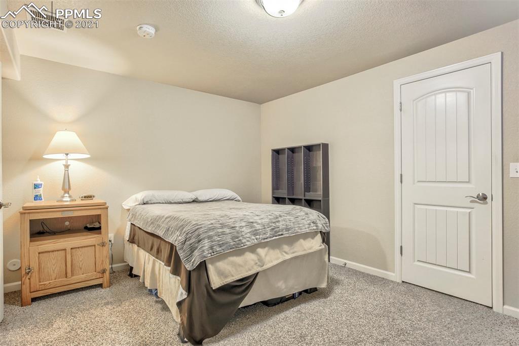 835 Citrine View Colorado Springs, CO 80921 - Photo 34 of 50 a bedroom with a bed and a dresser