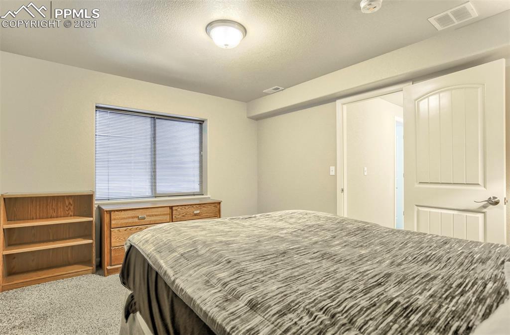 835 Citrine View Colorado Springs, CO 80921 - Photo 36 of 50 a bedroom with a bed and a dresser