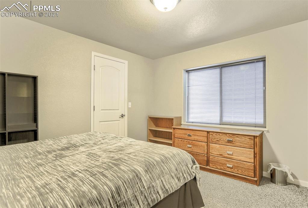 835 Citrine View Colorado Springs, CO 80921 - Photo 37 of 50 a bedroom with a bed and a dresser
