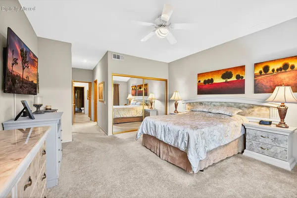 a spacious bedroom with a bed and a flat screen tv