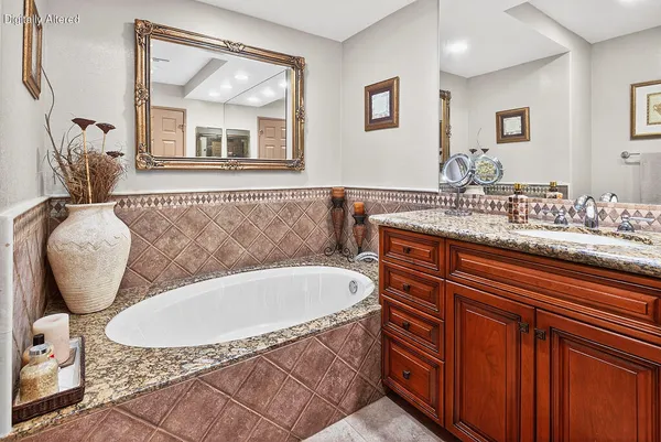 a bathroom with a tub sink and mirror