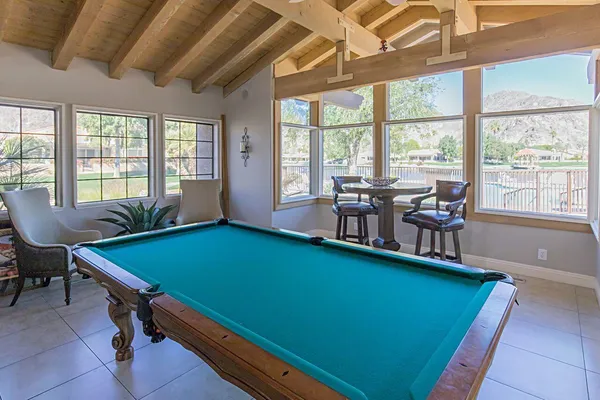 a room with pool table and windows