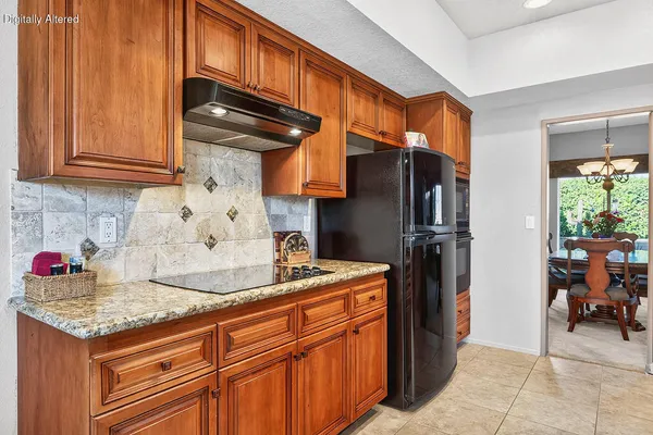 a kitchen with stainless steel appliances granite countertop a refrigerator and a sink