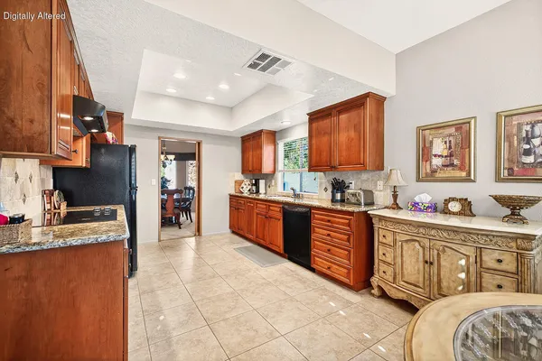 a large kitchen with stainless steel appliances granite countertop a sink and cabinets