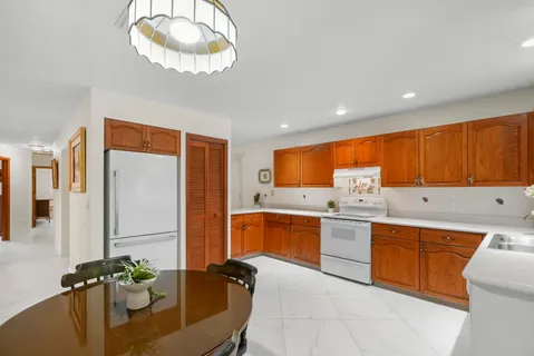 a kitchen with stainless steel appliances granite countertop sink stove refrigerator and cabinets