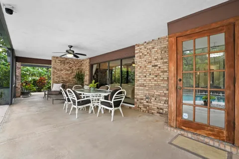 a dining room with furniture and a floor to ceiling window