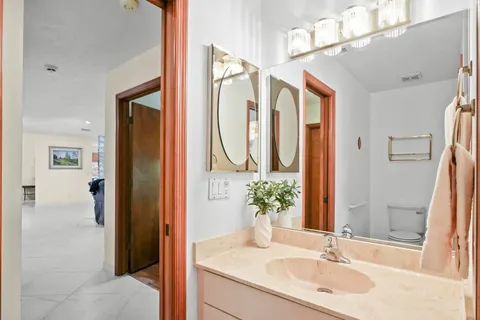 a bathroom with a granite countertop sink and a mirror