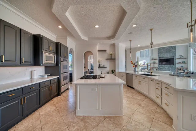 a large kitchen with stainless steel appliances lots of counter space and a sink