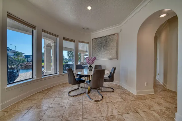 a living room with couches a table and chairs with a large window