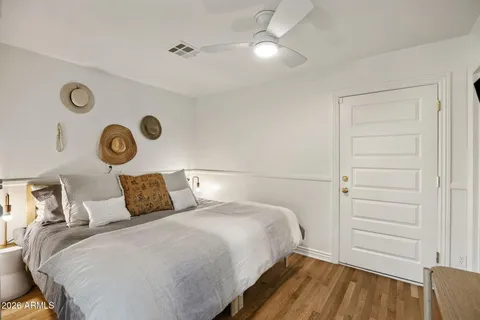 a bedroom with a bed and a lamp on dresser