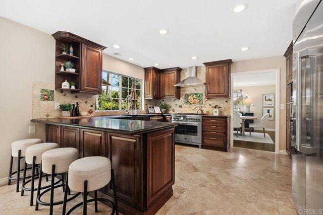 a kitchen with granite countertop a refrigerator and a sink