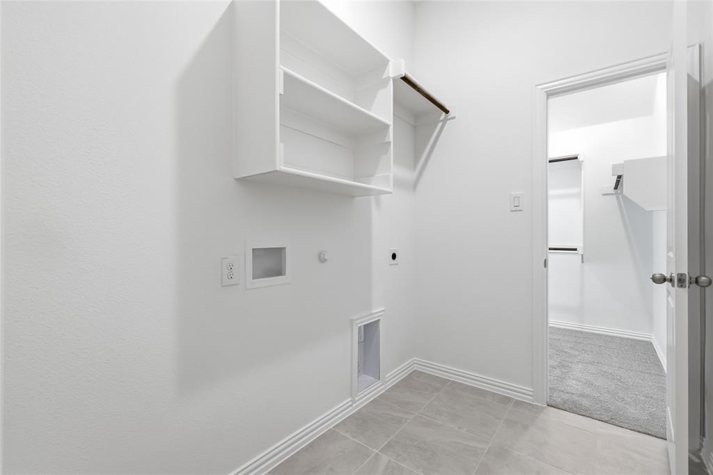 2529 Rivers W Road Anna, TX 75409 - Photo 29 of 40 Laundry area featuring built-in shelving, a clothes hanging rod, and tile flooring