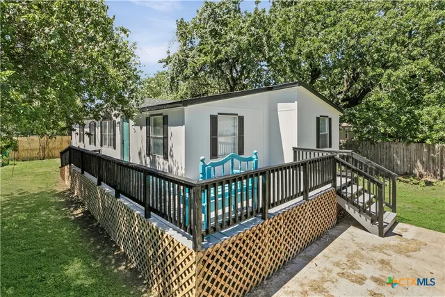 a view of a house with wooden deck and backyard