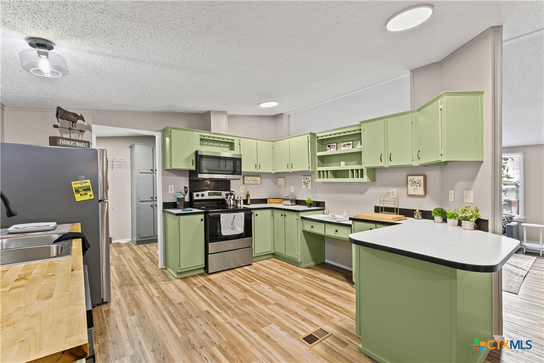 113 Austin Street Gatesville, TX 76528 - Photo 10 of 24 a kitchen with stainless steel appliances granite countertop a sink stove and refrigerator
