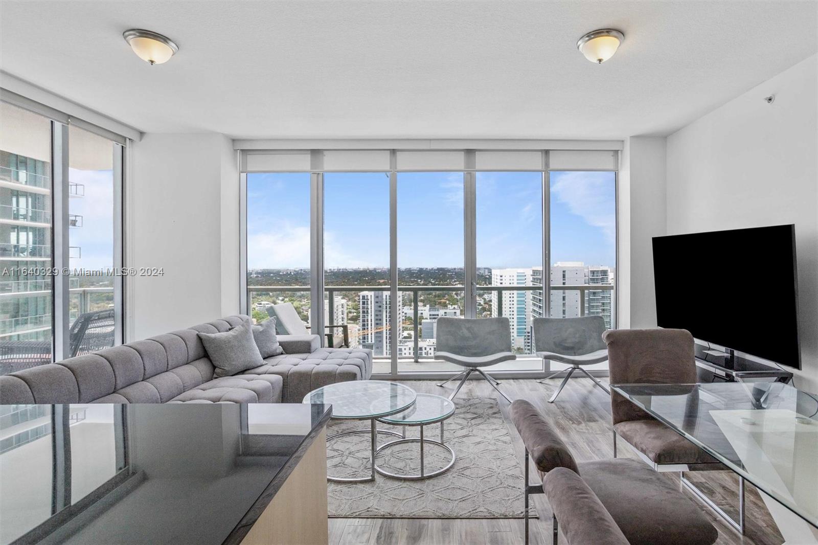 1111 Southwest 1st Avenue, Unit 3014N Miami, FL 33130 - Photo 2 of 36 a living room with furniture and a flat screen tv