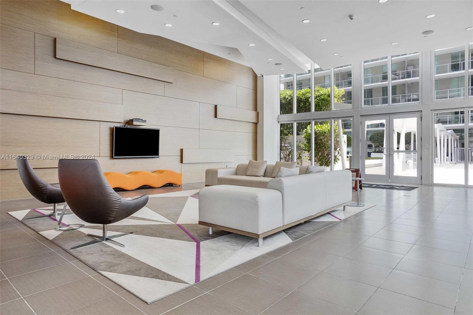 1111 Southwest 1st Avenue, Unit 3014N Miami, FL 33130 - Photo 26 of 36 a living room with furniture a flat screen tv and floor to ceiling window