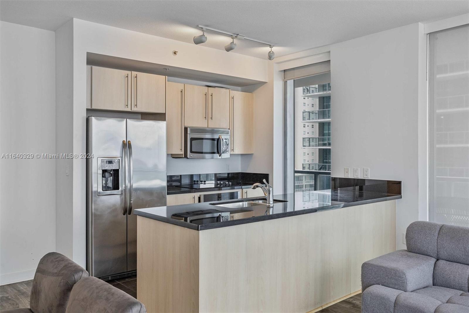 1111 Southwest 1st Avenue, Unit 3014N Miami, FL 33130 - Photo 7 of 36 a kitchen with stainless steel appliances granite countertop a refrigerator a stove a sink and white cabinets