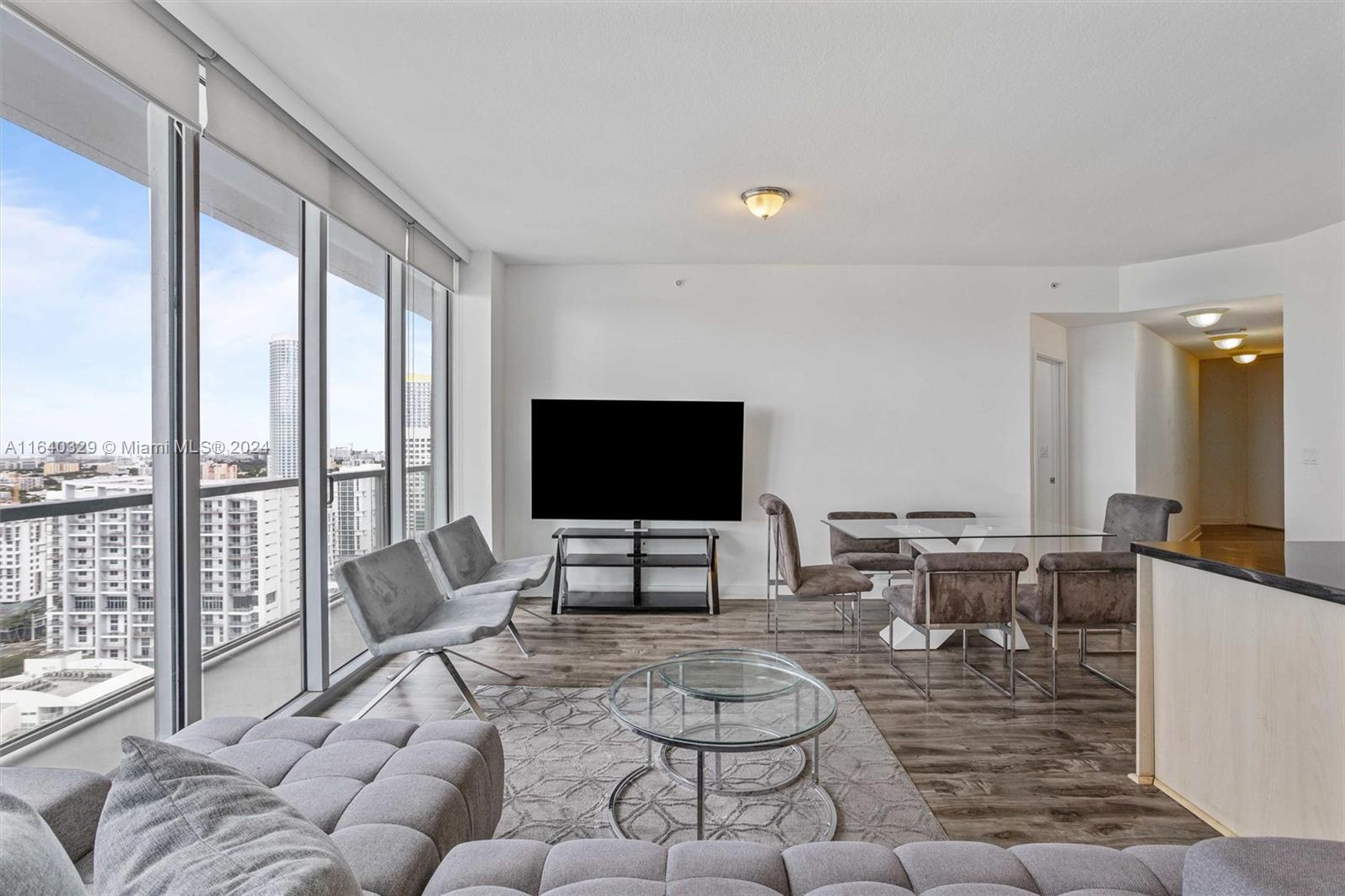 1111 Southwest 1st Avenue, Unit 3014N Miami, FL 33130 - Photo 9 of 36 a living room with furniture large window and a flat screen tv