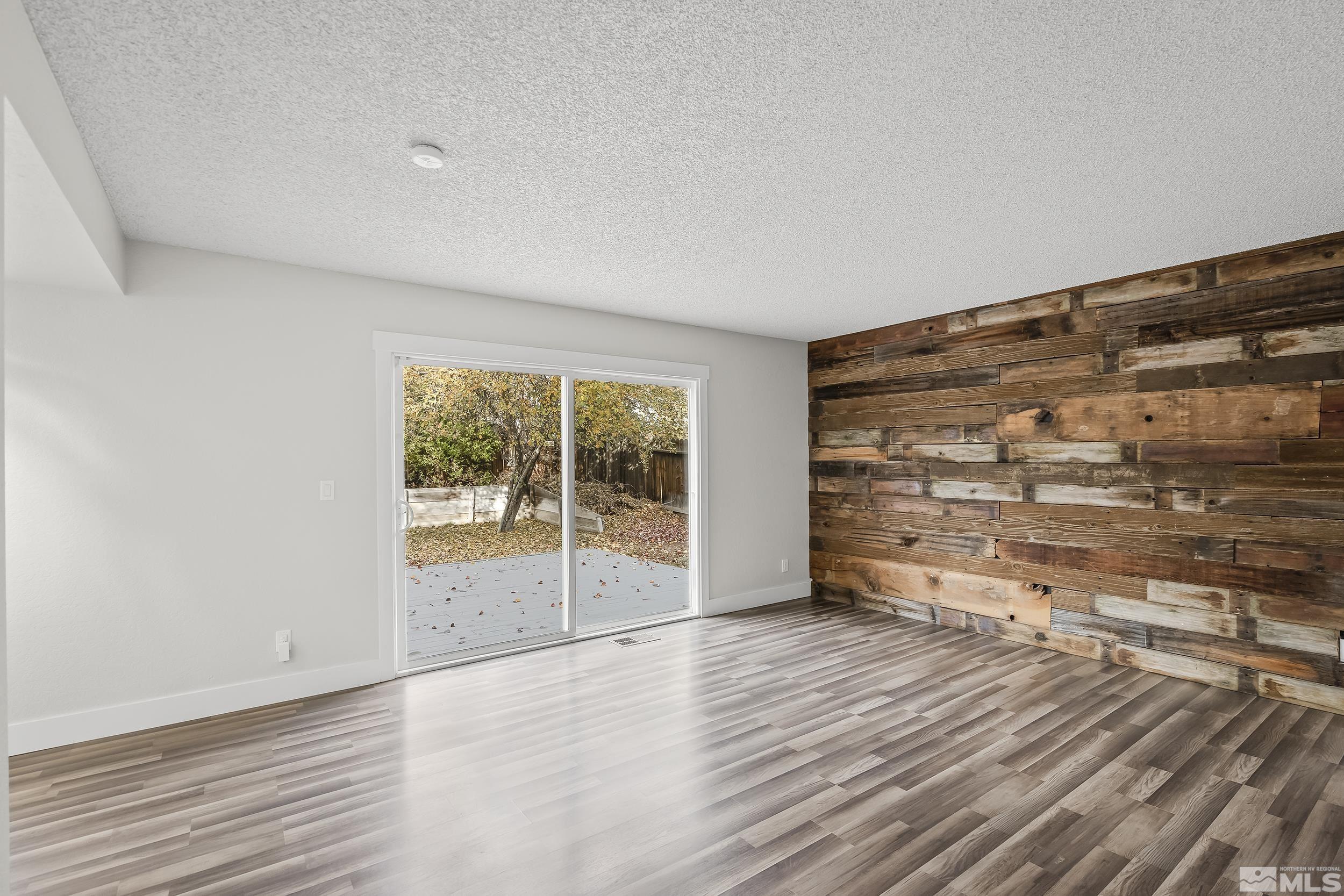 5651 West Rainbow Ridge Court Reno, NV 89523 - Photo 12 of 26 an empty room with wooden floor and windows