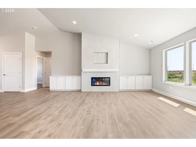 a view of empty room with wooden floor and window
