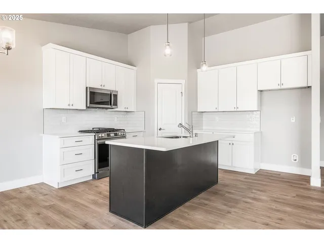 a kitchen with stainless steel appliances a sink stove and microwave