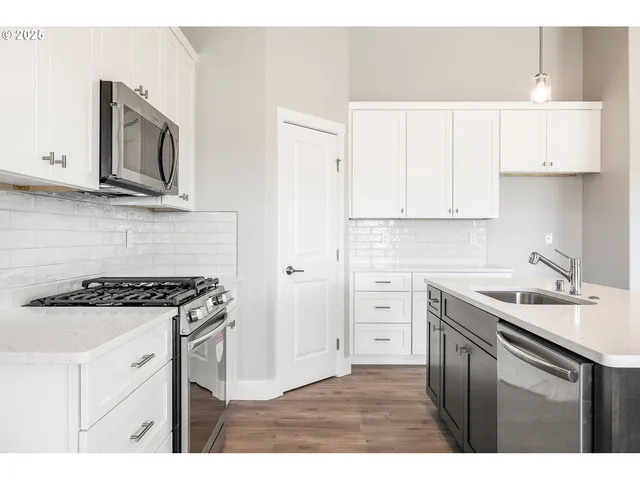 a kitchen with stainless steel appliances granite countertop a sink stove and cabinets
