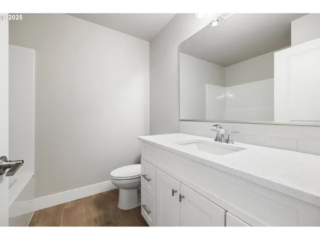 a bathroom with a granite countertop sink a toilet and a mirror