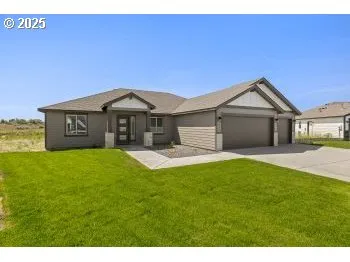a front view of a house with a garden and yard