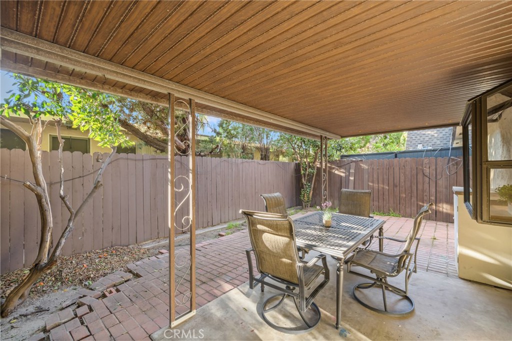 914 Fairview Avenue, Unit 13 Arcadia, CA 91007 - Photo 30 of 39 a view of a patio with table and chairs under an umbrella with a small yard