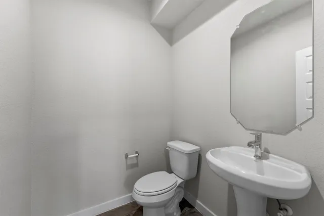 a bathroom with a sink a toilet and mirror