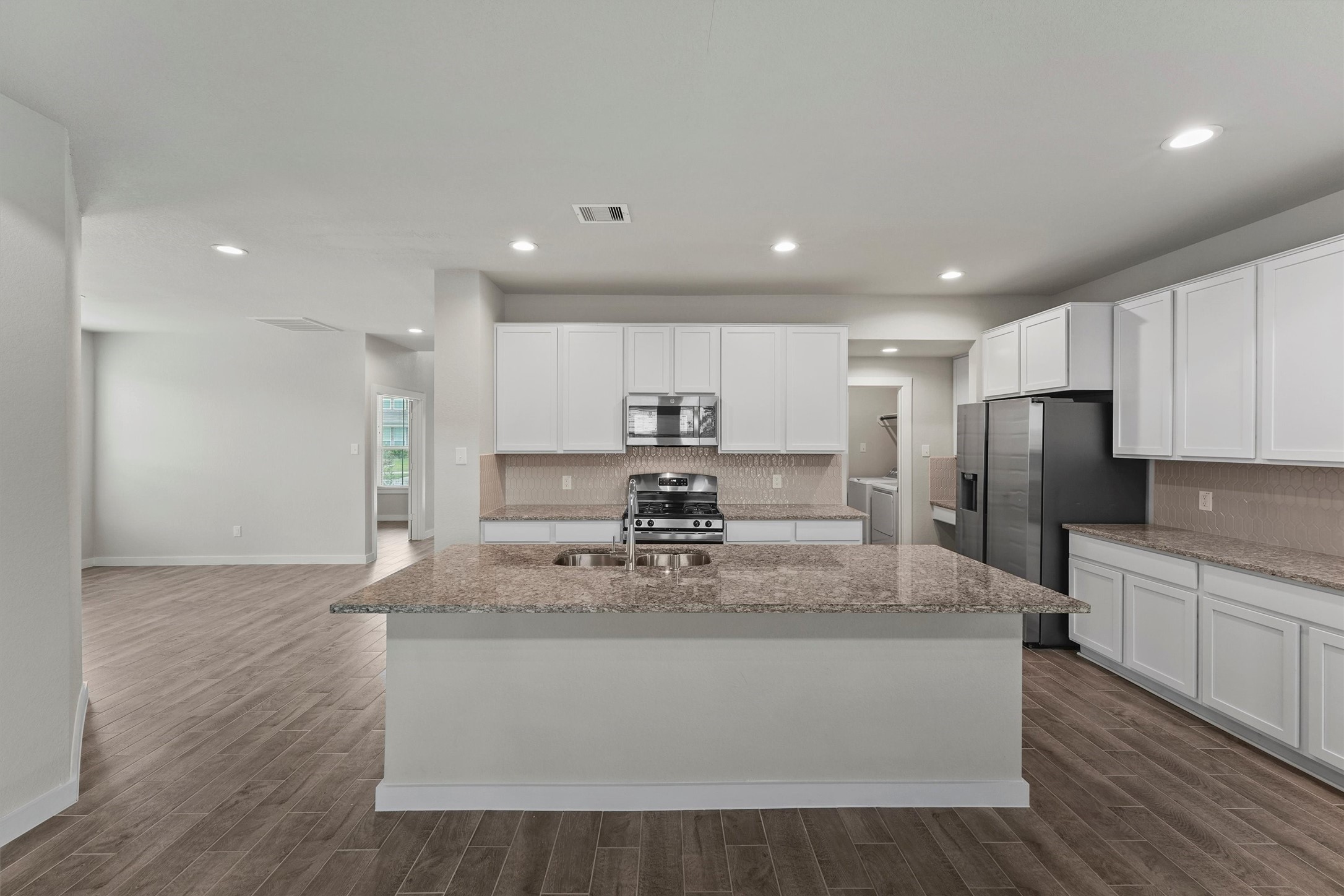 29357 Sycamore Cave Lane Spring, TX 77386 - Photo 2 of 21 a large kitchen with stainless steel appliances kitchen island a large counter top and a stove top oven