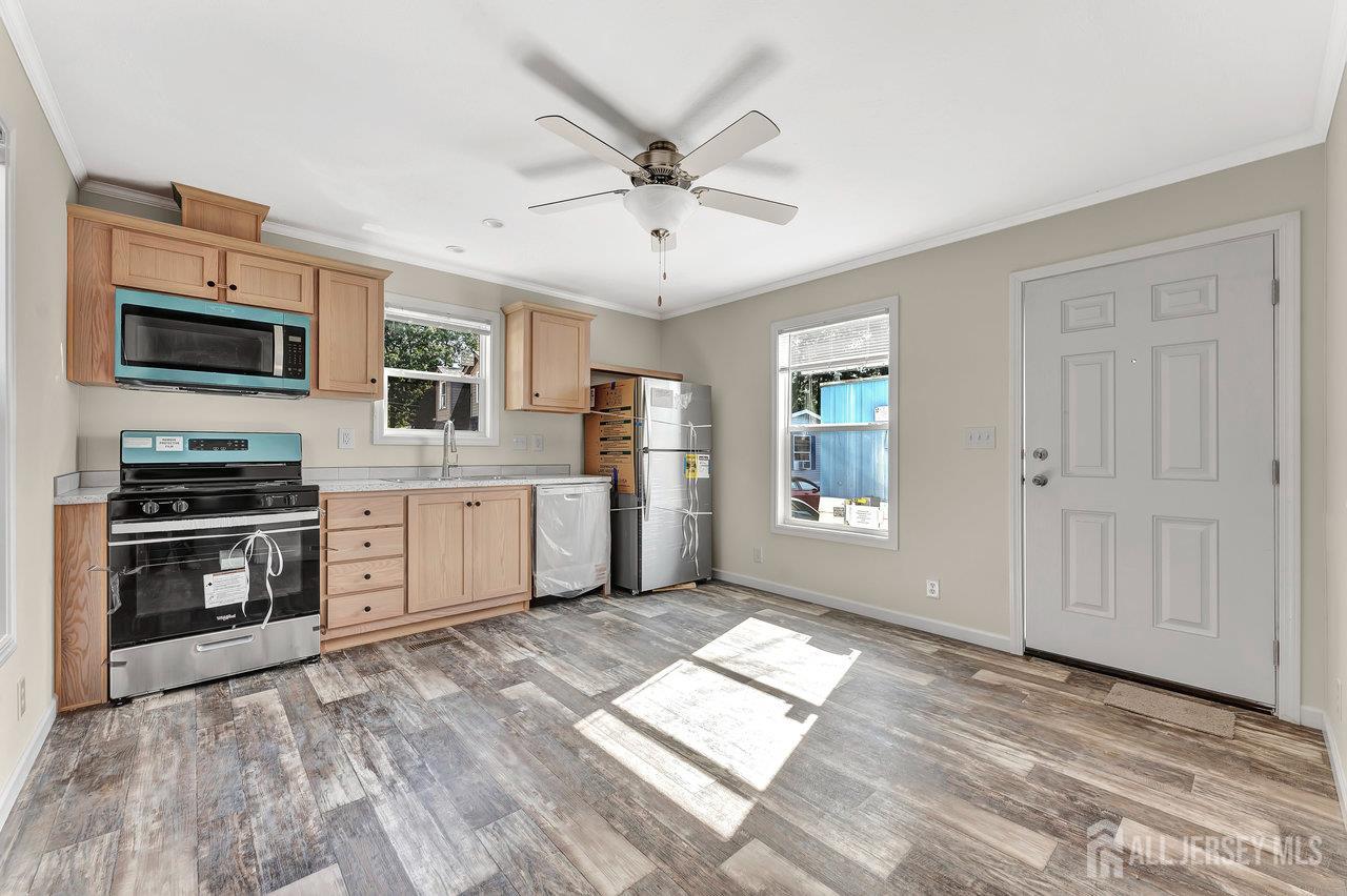 2505 Woodbridge Avenue, Unit 19L Edison, NJ 08817 - Photo 2 of 8 a kitchen with stainless steel appliances granite countertop a refrigerator a stove a sink dishwasher and a microwave oven with white cabinets