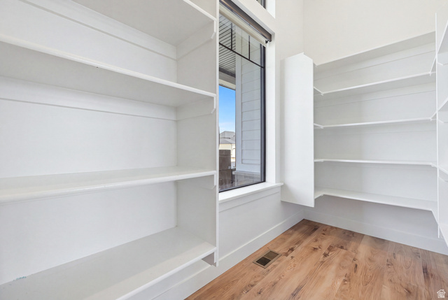 4331 West 475 South West Point, UT 84015 - Photo 14 of 46 Expansive pantry featuring extensive built-in shelving, wood-finish flooring, and a large window