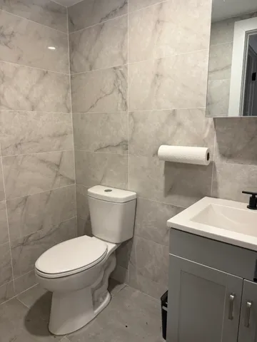 a white toilet sitting next to a bathroom sink