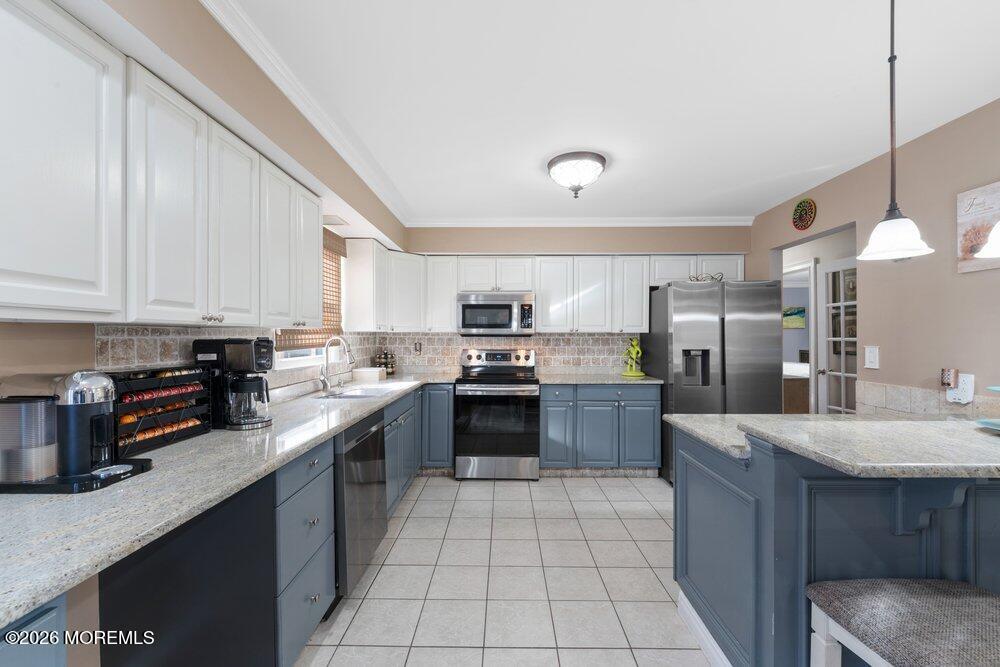 39 Cypress Road Toms River, NJ 08753 - Photo 15 of 52 a large kitchen with stainless steel appliances granite countertop a stove a sink dishwasher and a refrigerator