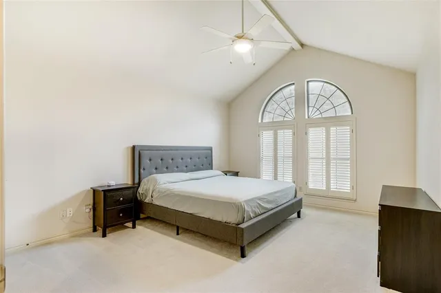 a bed sitting in a spacious bedroom next to a window